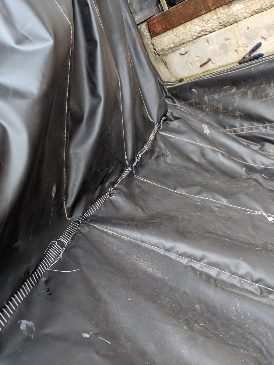 The same dock curtain corner after the tear was stitched closed