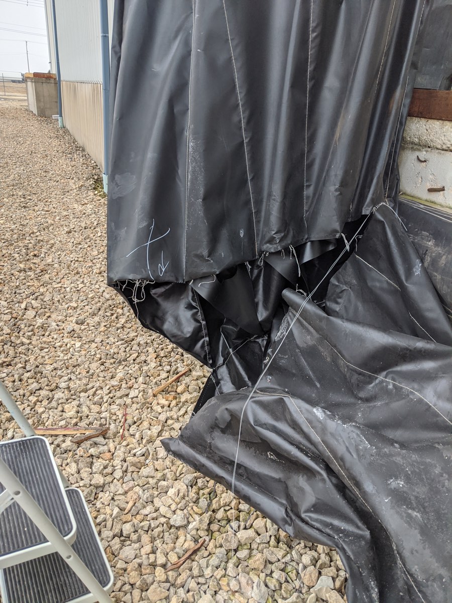 Dock curtain with the bottom corner torn open before repair